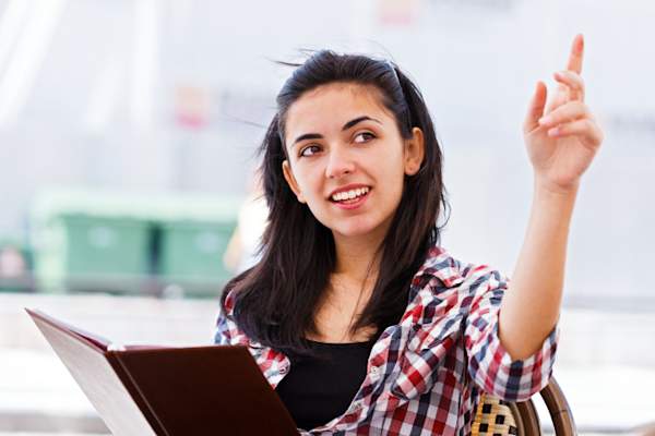Woman signaling waiter at a restaurant.