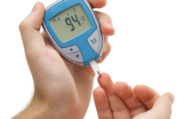 Person taking glucose reading with with glucose meter.