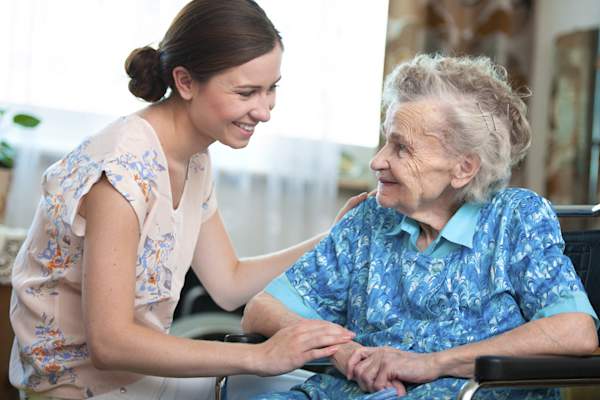 Woman smiling at senior woman.