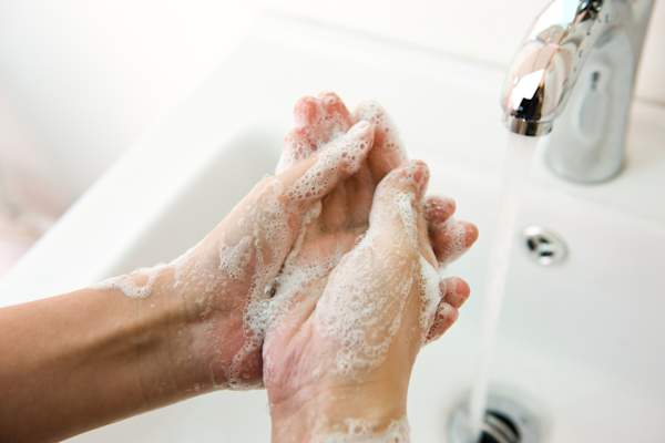Washing hands with soap and water.