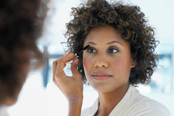 Woman putting on eye makeup.