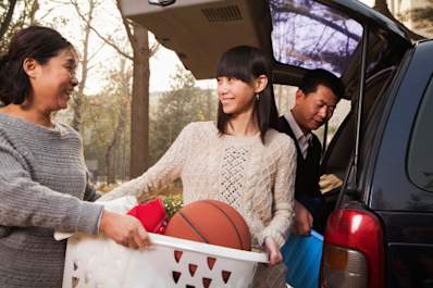 Young woman loading up a car to go back to school.