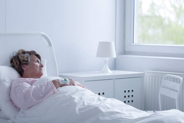 Senior woman ill and depressed at home in bed.
