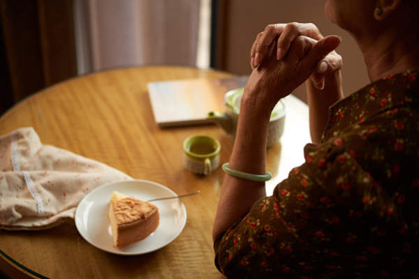 Senior eating along at kitchen table.