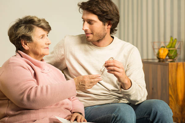 Adult son spending time with senior mother at home.