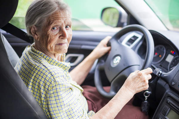 Elderly woman behind the wheel of her car.