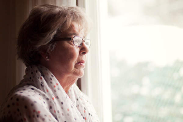 Senior woman looking out window.