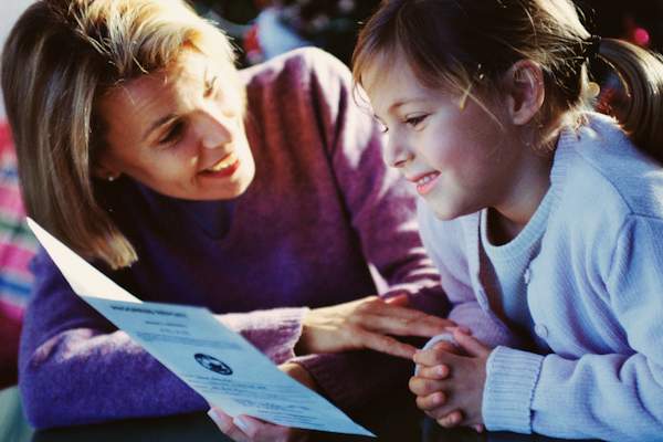 Happy mother and young son looking at progress report.