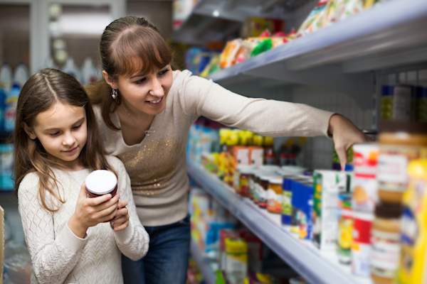 Mother and young daughter at grocery store shopping.