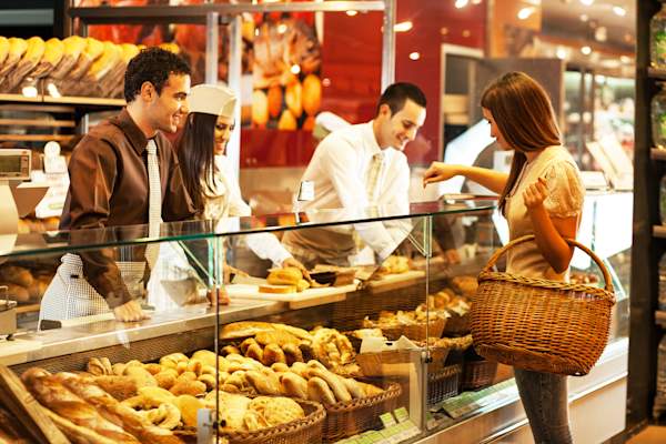 Woman picking up baked goods at bakery.