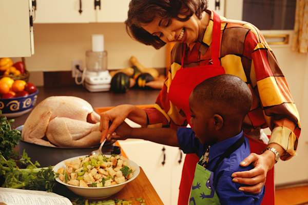 Mother embracing son while cooking.