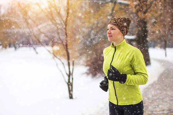 Woman jogging in the snow.
