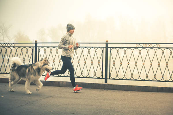 Woman taking an early morning run with her dog.