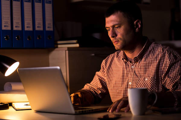Man with insomnia on laptop late at night.