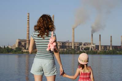 Mother and daughter looking at chemical plant near their home.