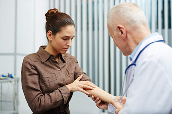 Doctor examining a patient's arm.
