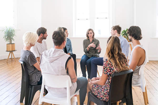 Young woman talking at support group meeting.