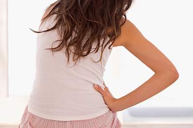 A woman waking up with stiffness and joint pain.