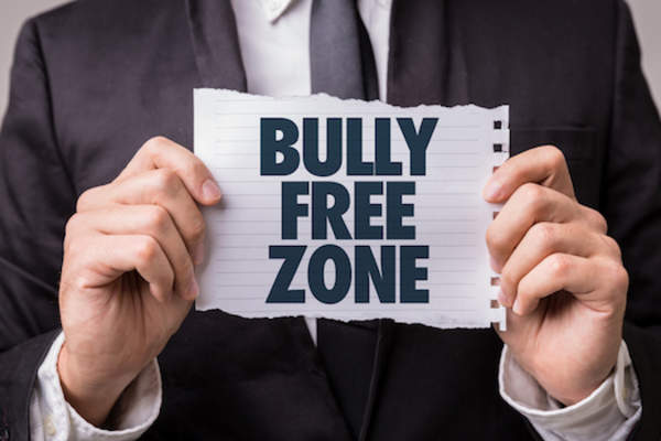 Principle holding bully free zone sign.