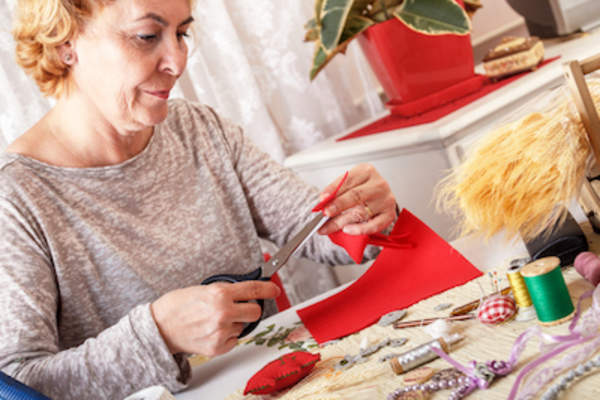 Woman using scissors to cut felt.