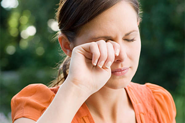 Woman rubbing her irritated eye.