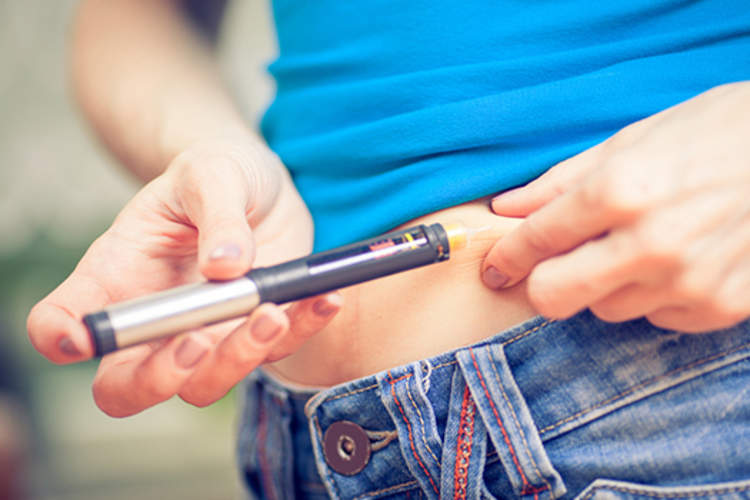 Woman injecting insulin into her stomach.