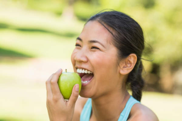young woman eating an apple image