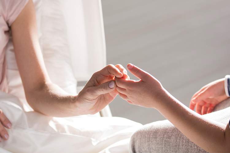 Caregiver and patient touching hands.