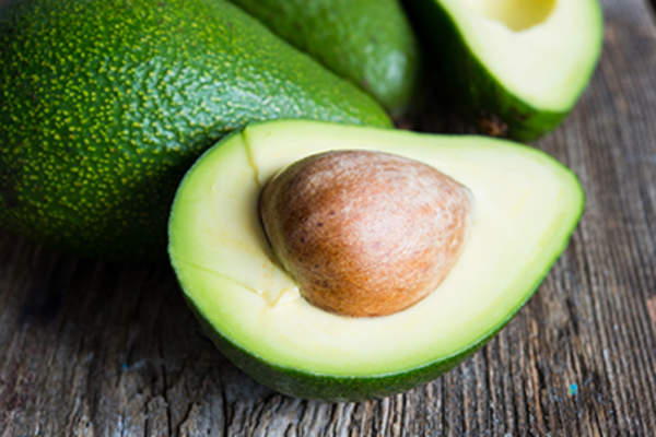 Ripe avocado on a wooden background.