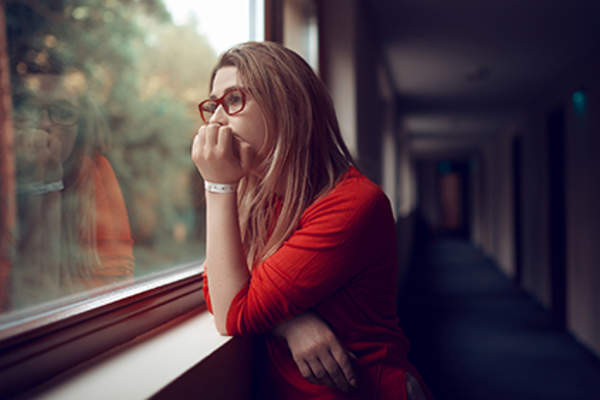 Pensive woman staring out a window.