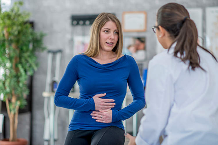 Woman and doctor discussing symptoms.