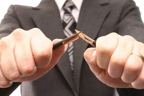 Stressed businessman snapping a pencil.