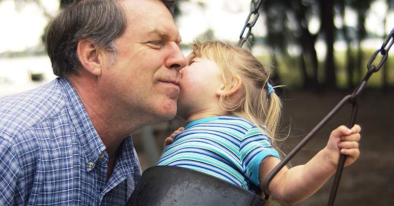 Daughter kissing father's cheek