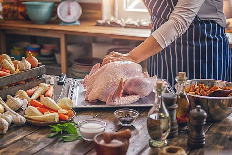 Woman making turkey dinner in kitchen.