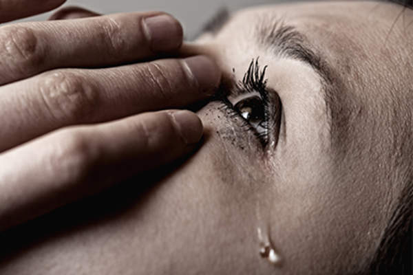 Tear rolling down woman's cheek.