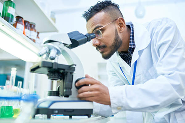 Medical researcher looking through a microscope.