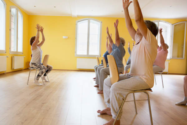 Woman leads yoga class.