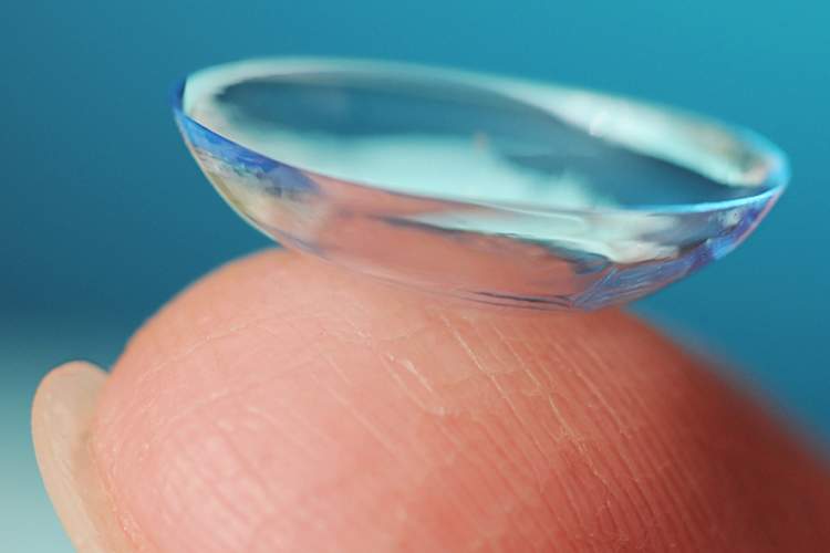 Close-up of contact lens on finger.