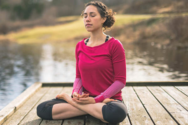 Woman meditating outdoors.