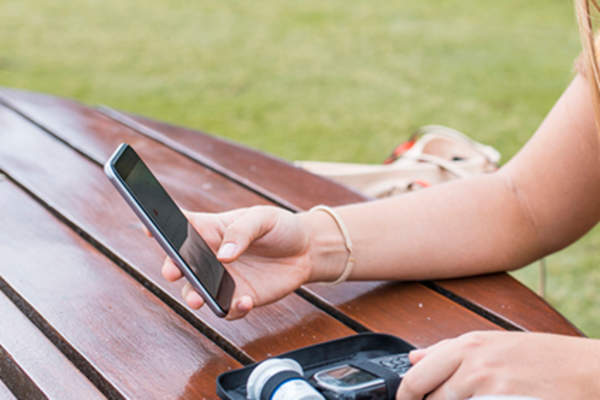 Young woman checking blood sugar using diabetes app.