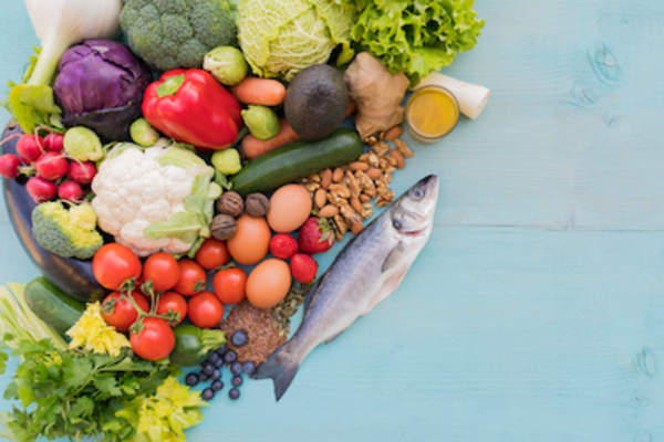 Fruits, vegetables and fish on blue wood table.