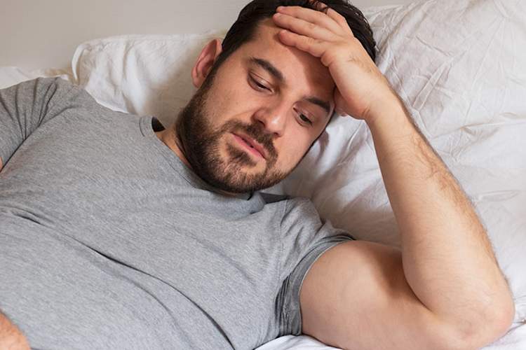 Man awake in bed at night.