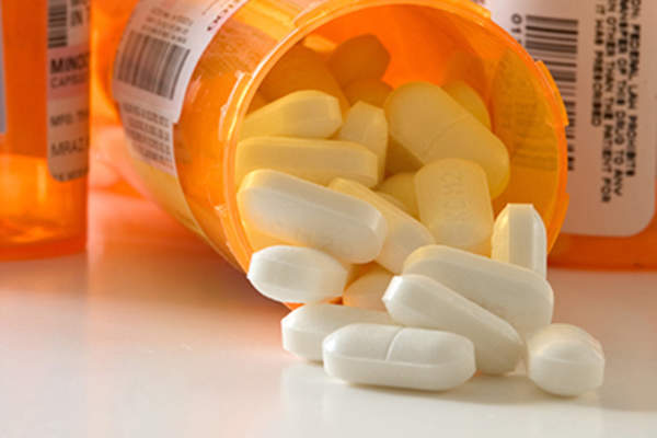 Caplets spilling from medicine bottle.
