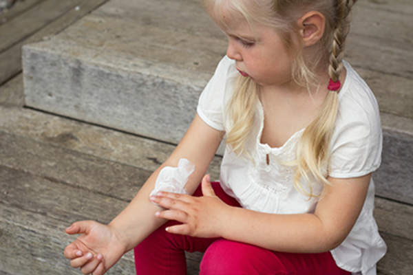 Child rubbing in moisturizer.