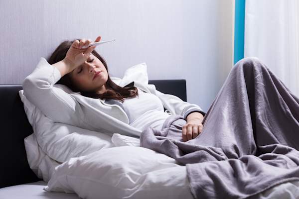 Woman in bed with fever.