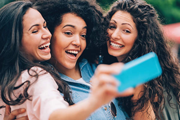 Laughing friends posing for a selfie.