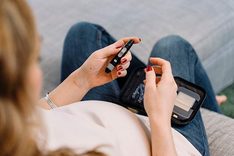 Pregnant woman monitoring her blood glucose levels