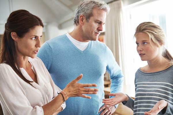 Teen and parents argue in living room.