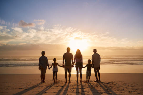 Family together facing sunset.