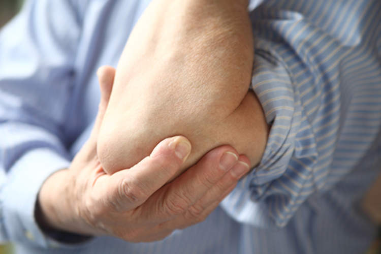 Man touching his sore elbow.
